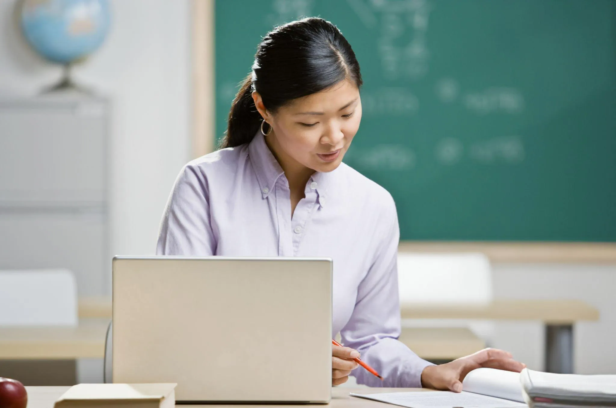A teacher is checking a book